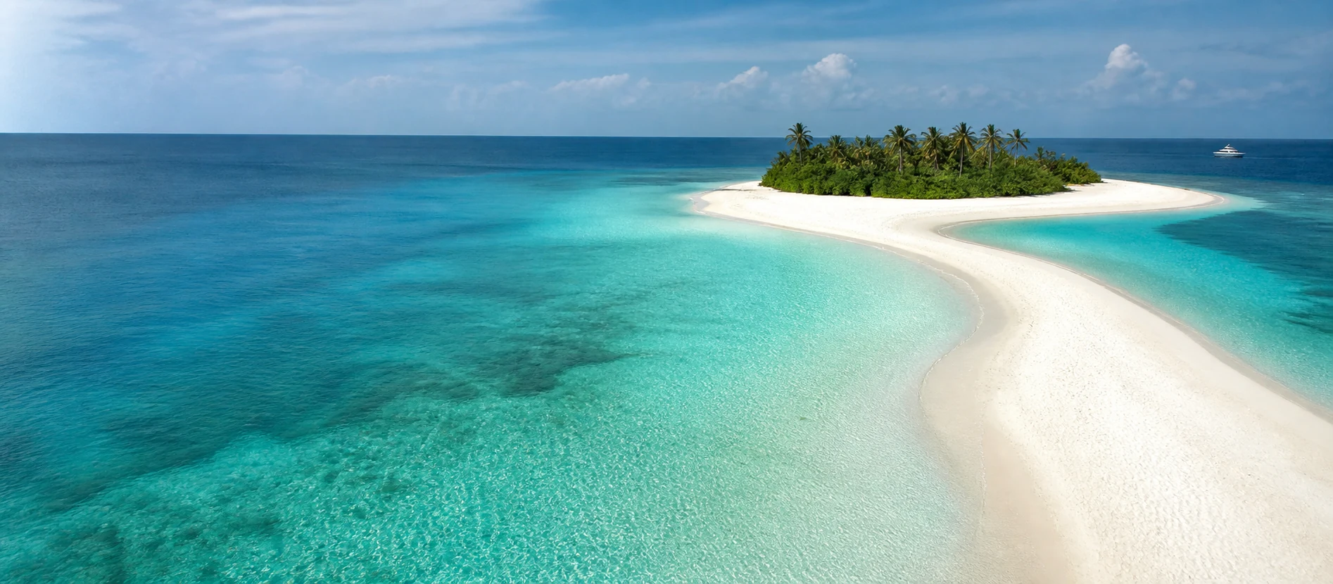 Turquoise Maldivian lagoon, a crescent of white sand and palm-fringed island